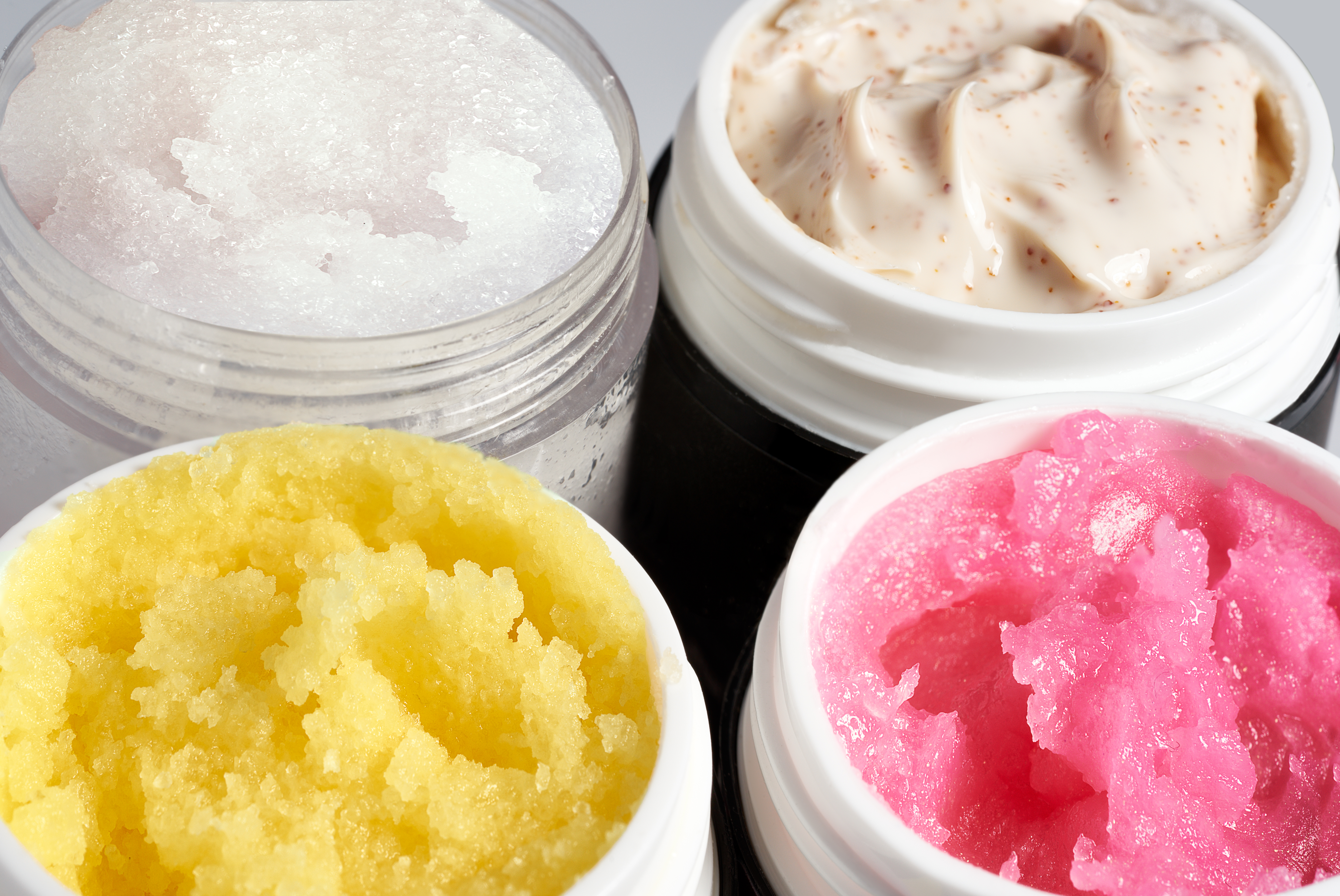 Containers with natural face or body scrub, close up, top view
